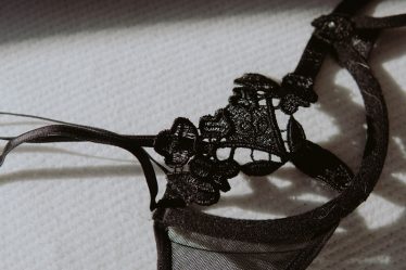 black lace brassiere on white textile