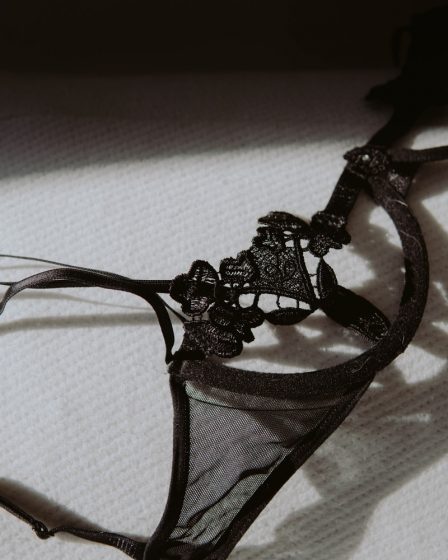 black lace brassiere on white textile