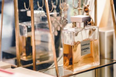 clear glass perfume bottle on glass shelf