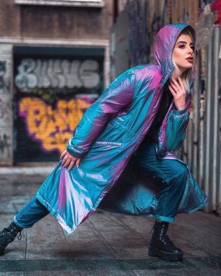 woman in purple leather jacket and black pants sitting on sidewalk during daytime