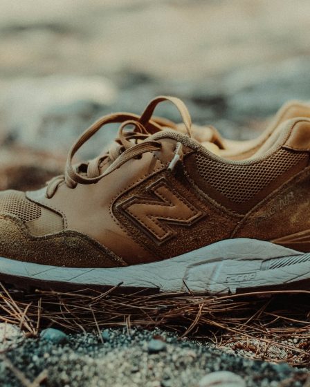 unpaired brown and white New Balance athletic shoe on ground