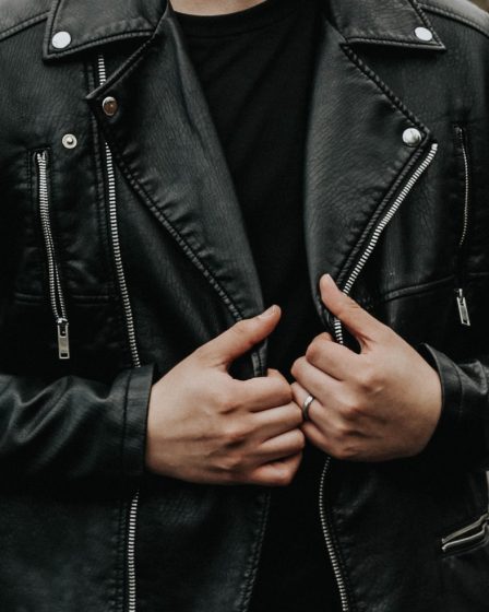man holding his leather jacket