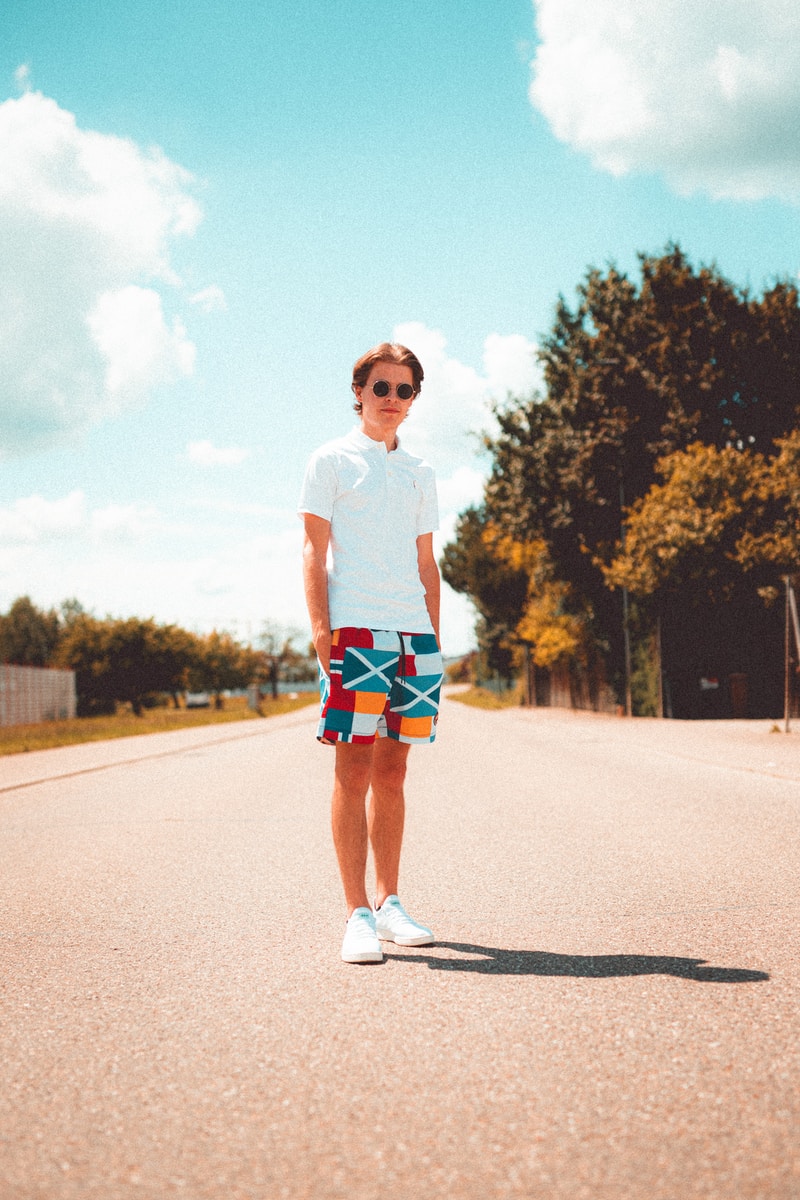 woman in white crew neck t-shirt and blue denim shorts standing on road during daytime