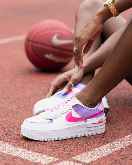 person wearing white and pink nike sneakers