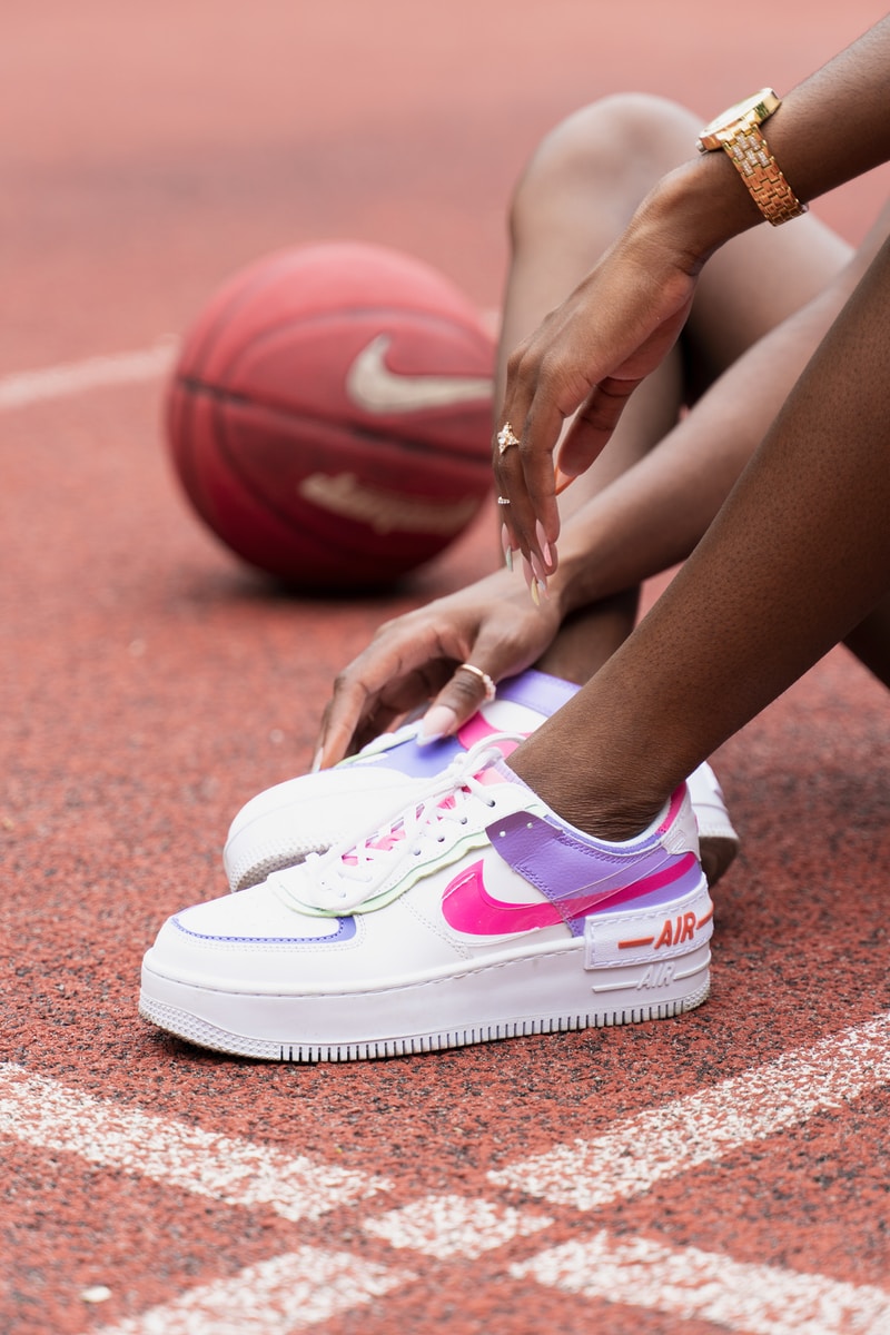 person wearing white and pink nike sneakers