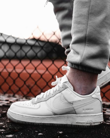 person in gray pants wearing white nike air force 1 low