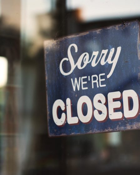 Sorry we're closed signage hanged on glass door