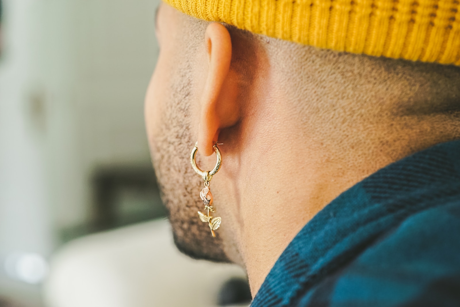 person wearing gold-colored unpaired earring
