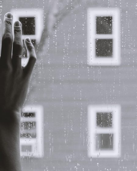 grayscale photo of woman right hand on glass