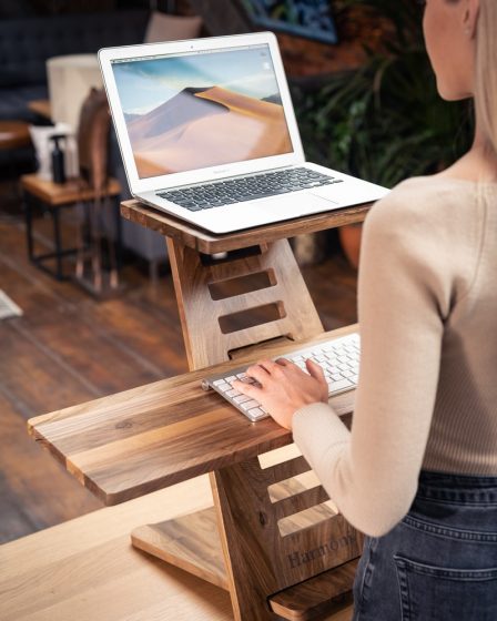 woman in white long sleeve shirt sitting on brown wooden chair using macbook air