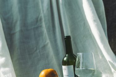 orange fruit beside wine bottle on table