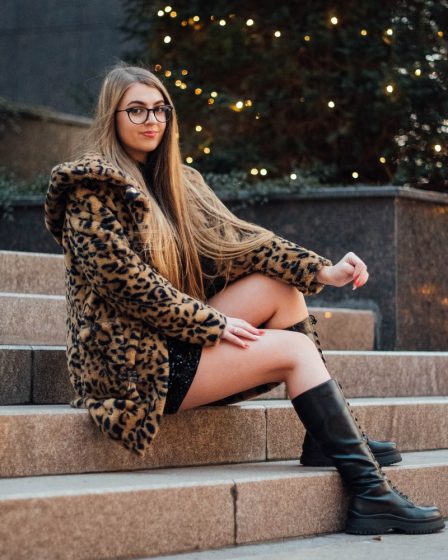 woman in brown leopard print coat sitting on concrete stairs