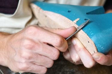person carving blue footwear