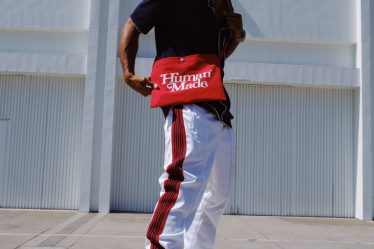 man in red and white crew neck t-shirt and white pants