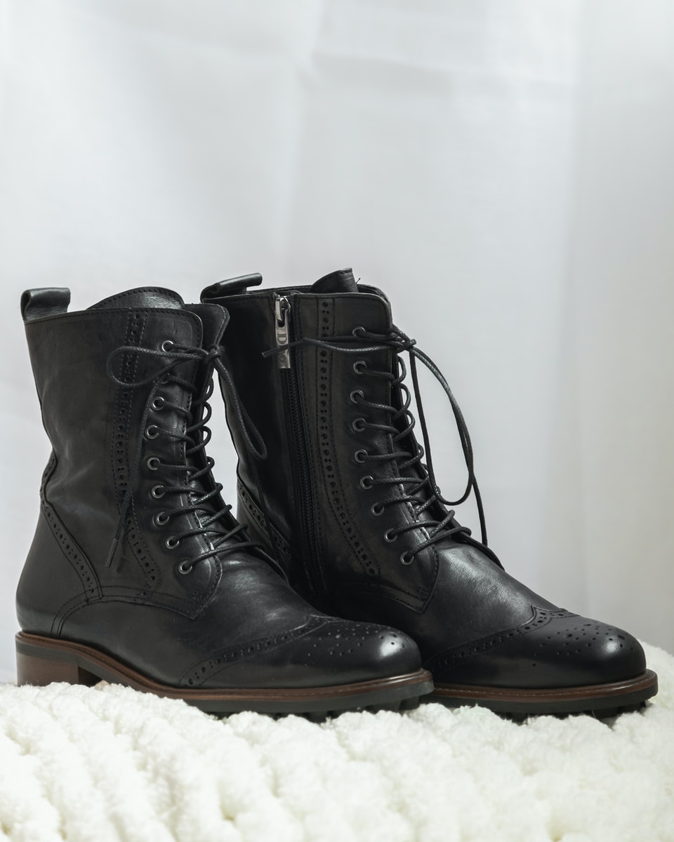 black leather boots on white textile