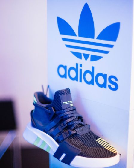 shallow focus photography of unpaired gray adidas sports shoe