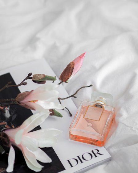 pink perfume bottle on white textile