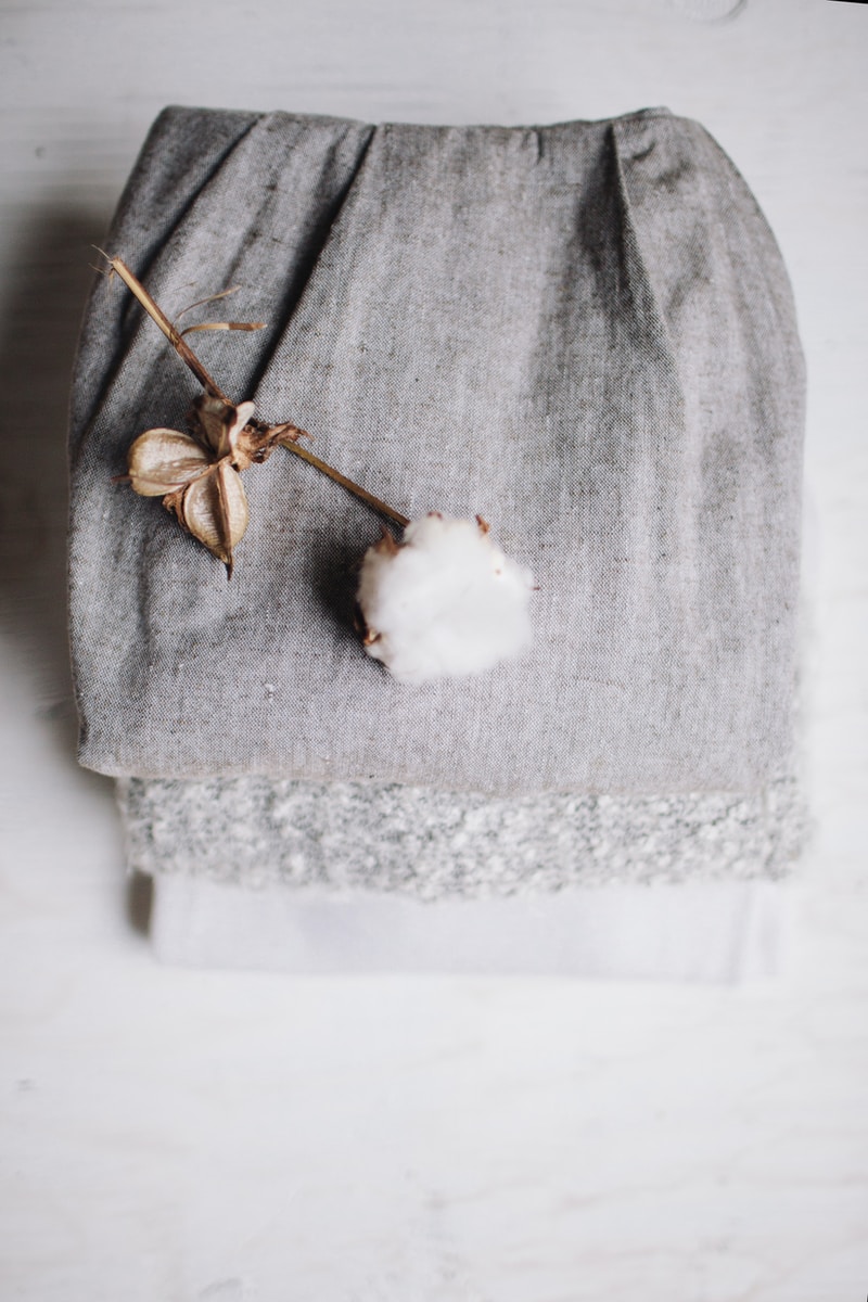 white cotton poppy on top of grey textile