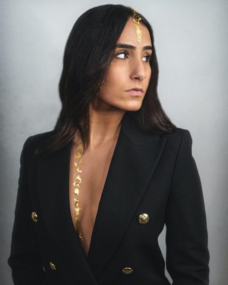 woman in black blazer and gold necklace