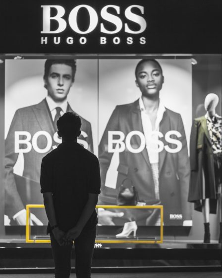 man standing in front of Boss Hugo Boss store