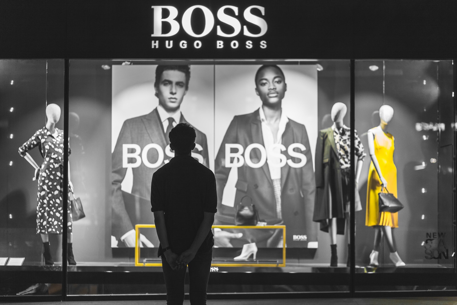 man standing in front of Boss Hugo Boss store