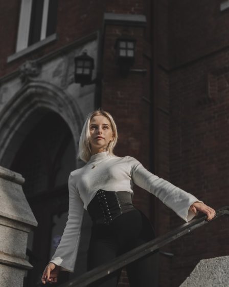 woman in white long sleeve shirt and black skirt standing on stairs