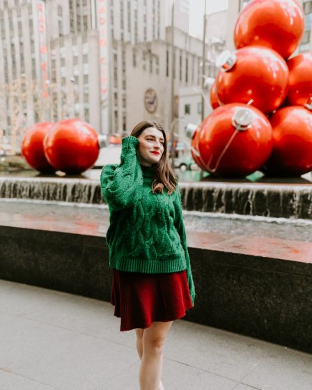 woman in green long sleeve dress holding red balloons