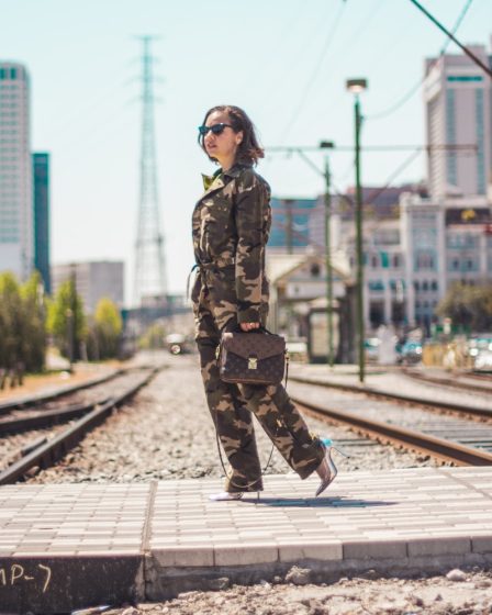 woman wearing camouflage soldier uniform carrying brown 2-way leather bag