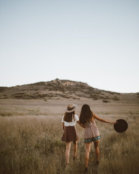 two women walking around near mountain at daytime